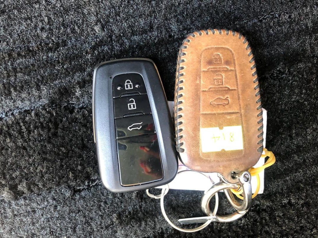 Car key fob with leather case on a textured surface